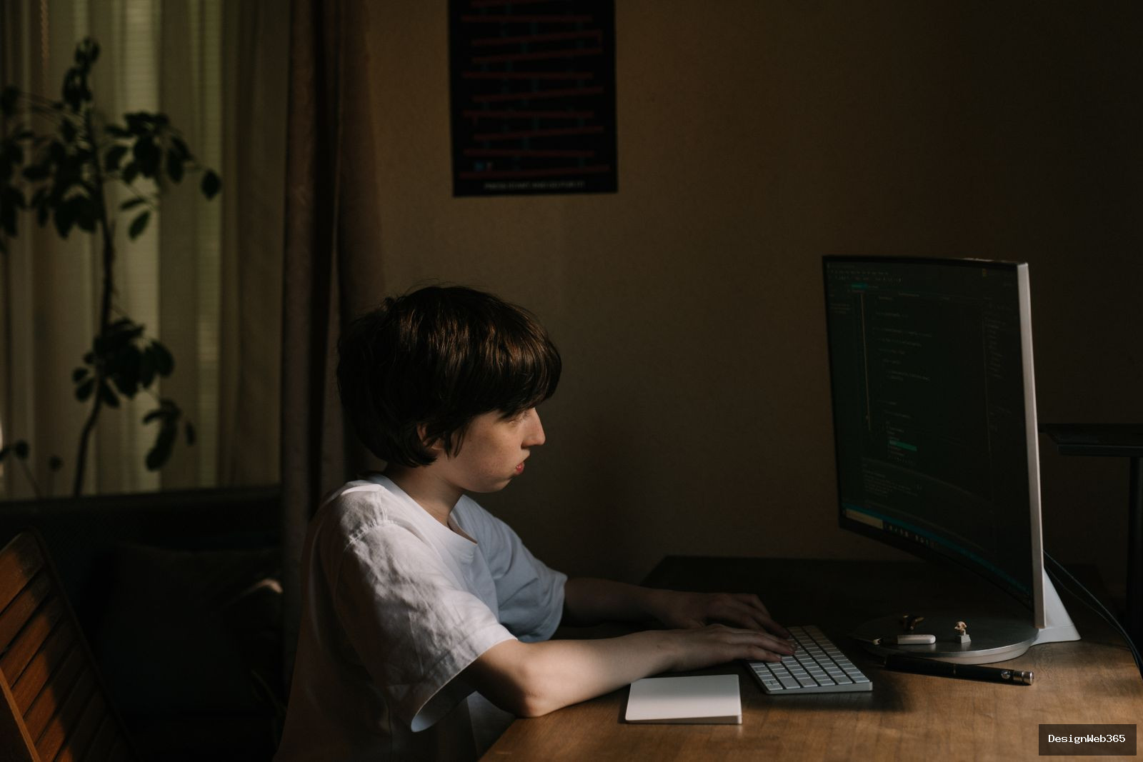 Jeune garcon concentre devant un ecran d ordinateur affichant du code de developpement