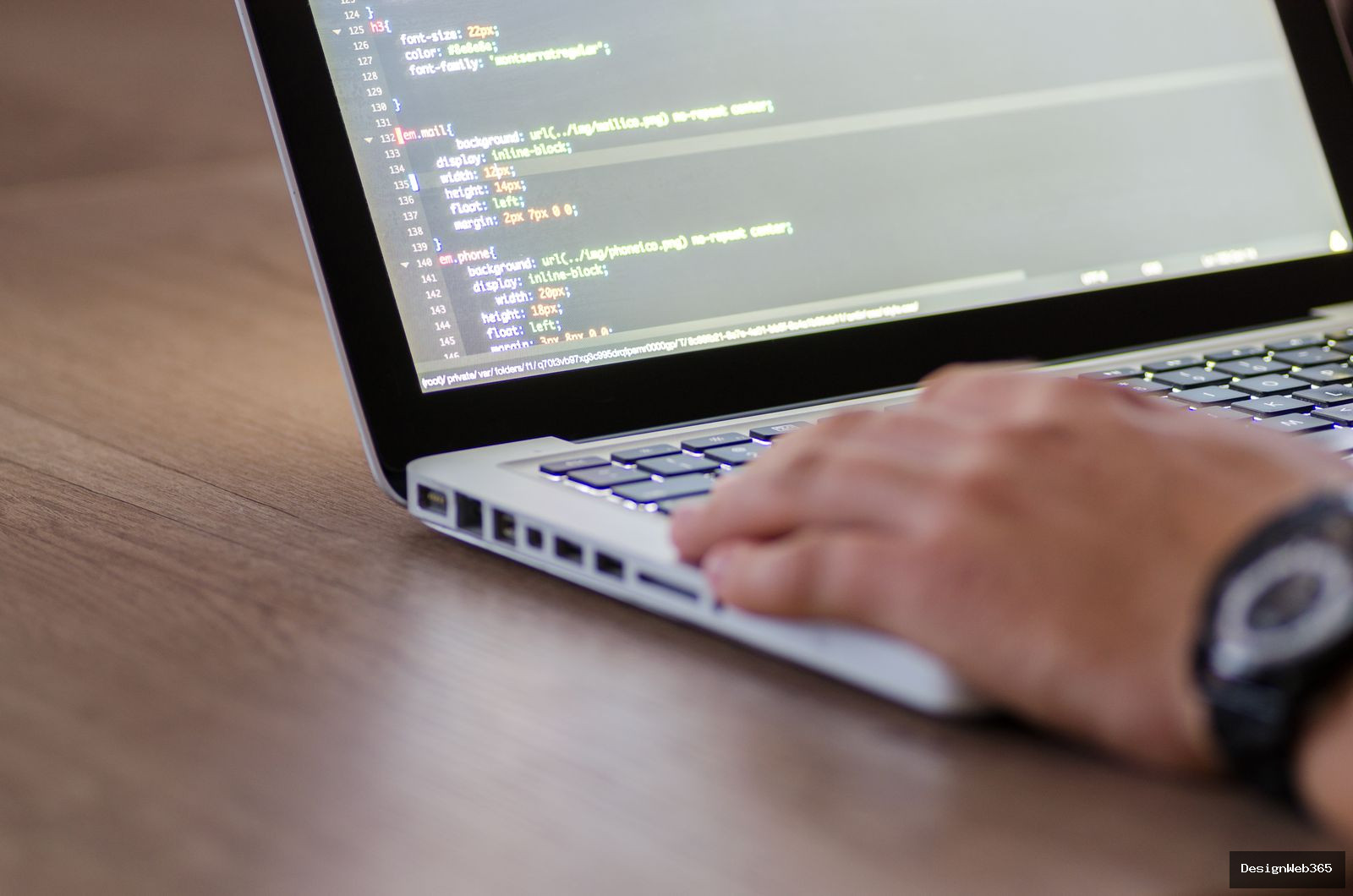 Personne codant sur un ordinateur portable avec des lignes de code affichees a l ecran