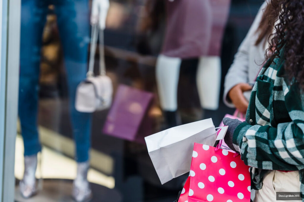 Clientes avec des sacs de shopping devant une vitrine de magasin