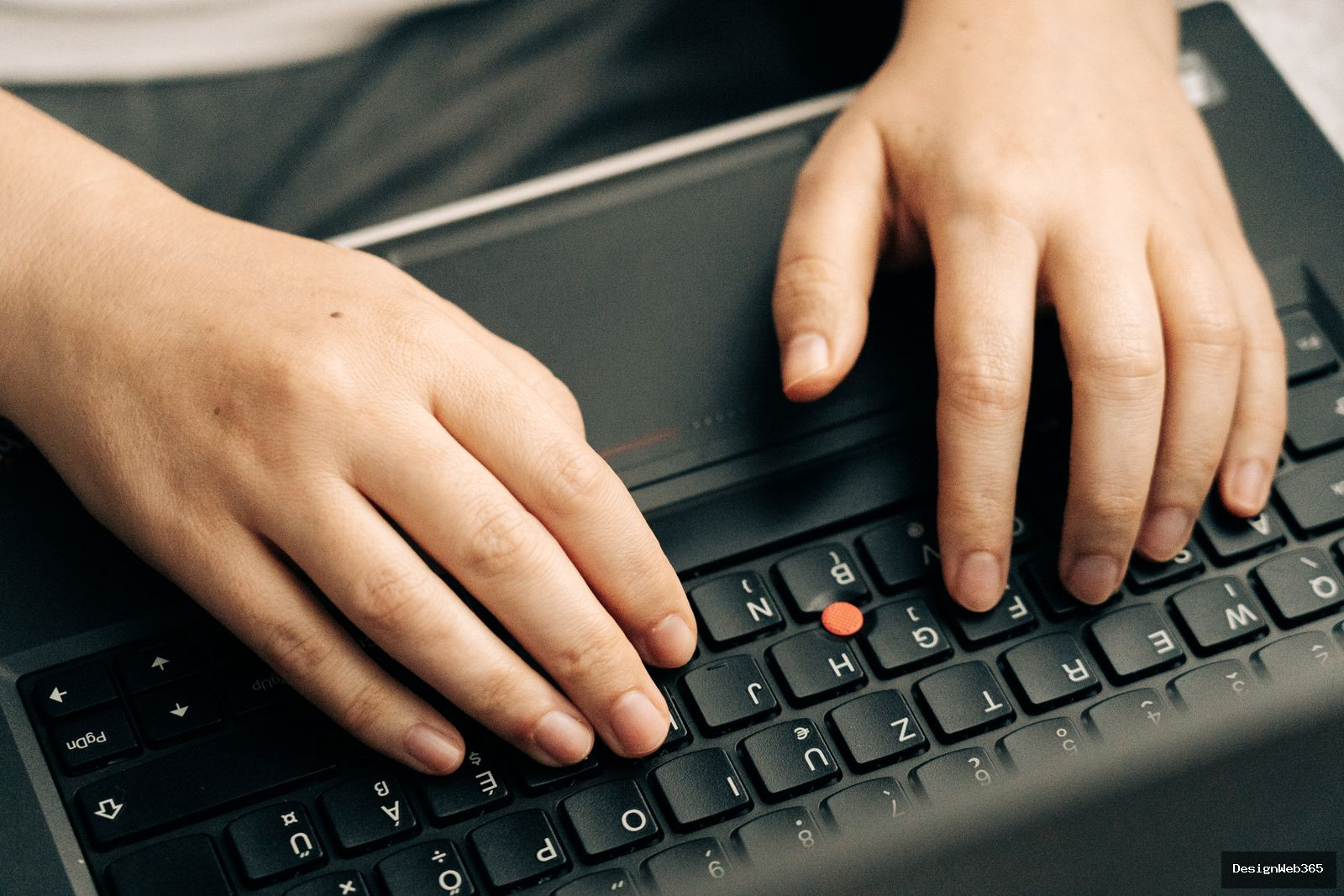 Gros plan de deux mains tapant sur le clavier d'un ordinateur portable