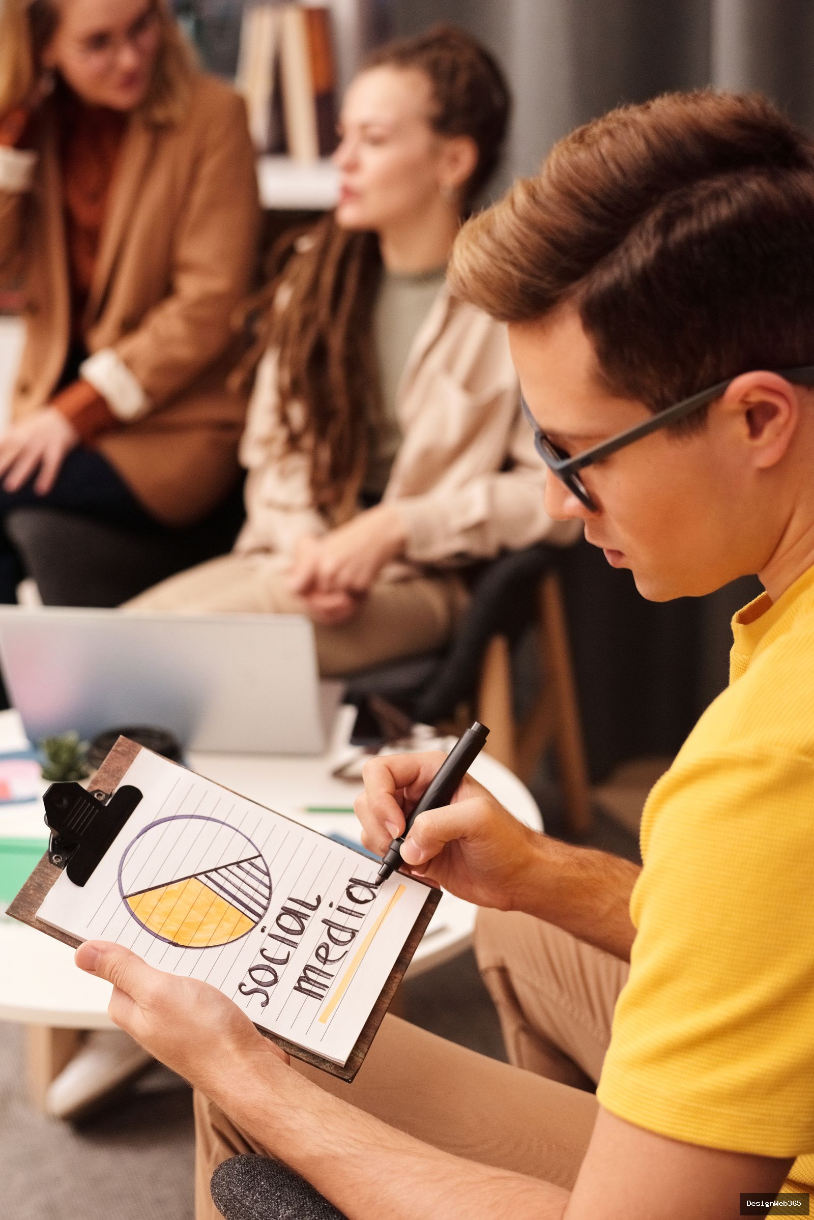 Equipe en reunion dessinant un schema Social Media sur un bloc-notes