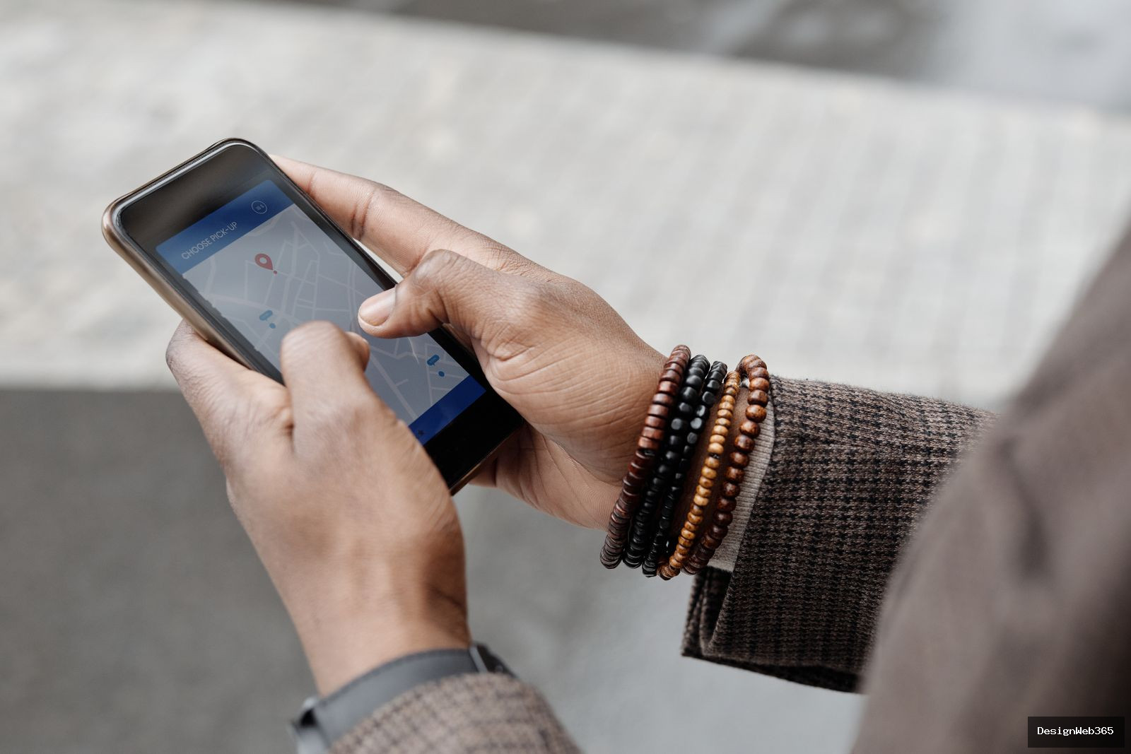 Mains tenant un smartphone avec une application de navigation GPS en exterieur