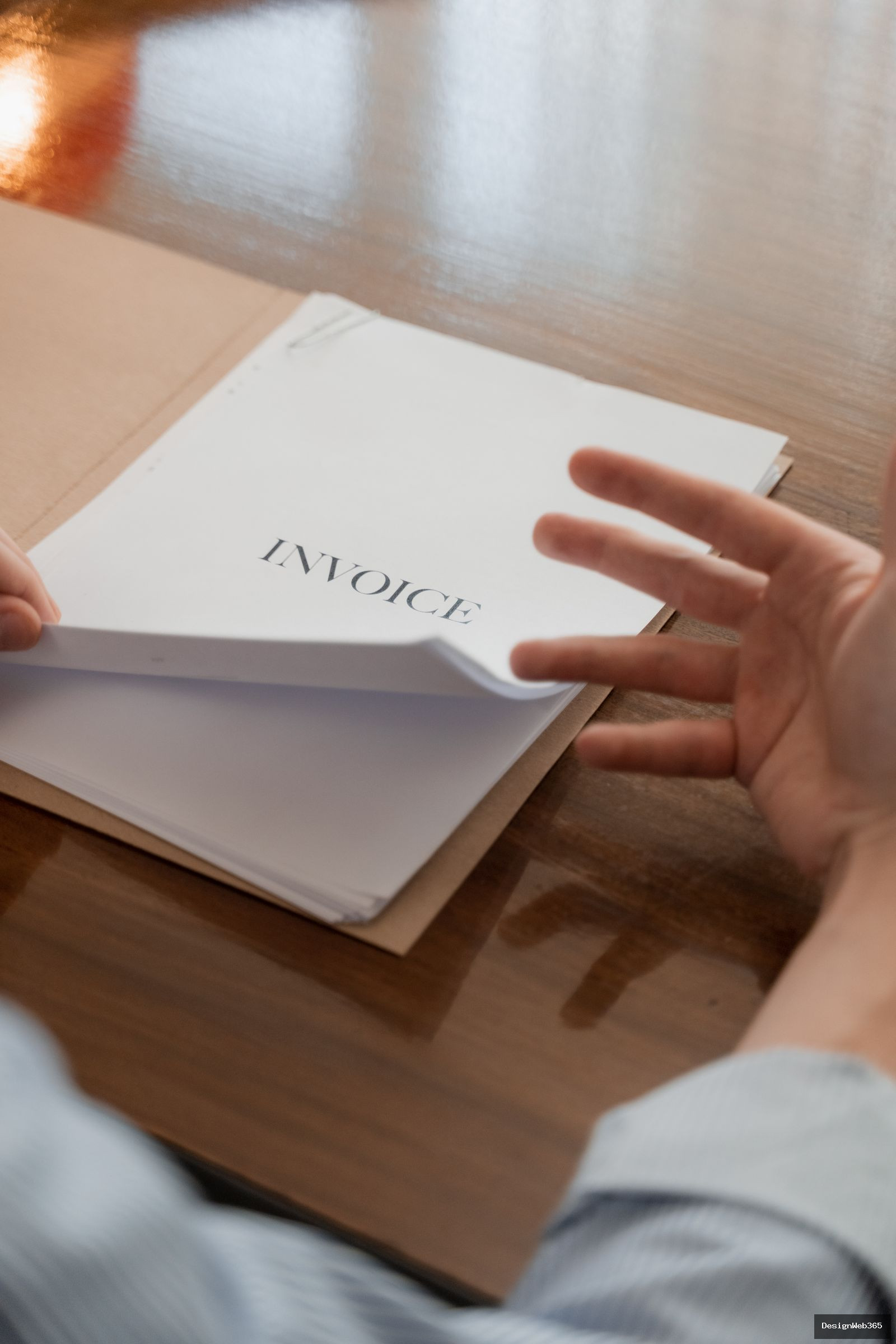 Main tenant des factures papier sur une table de bureau