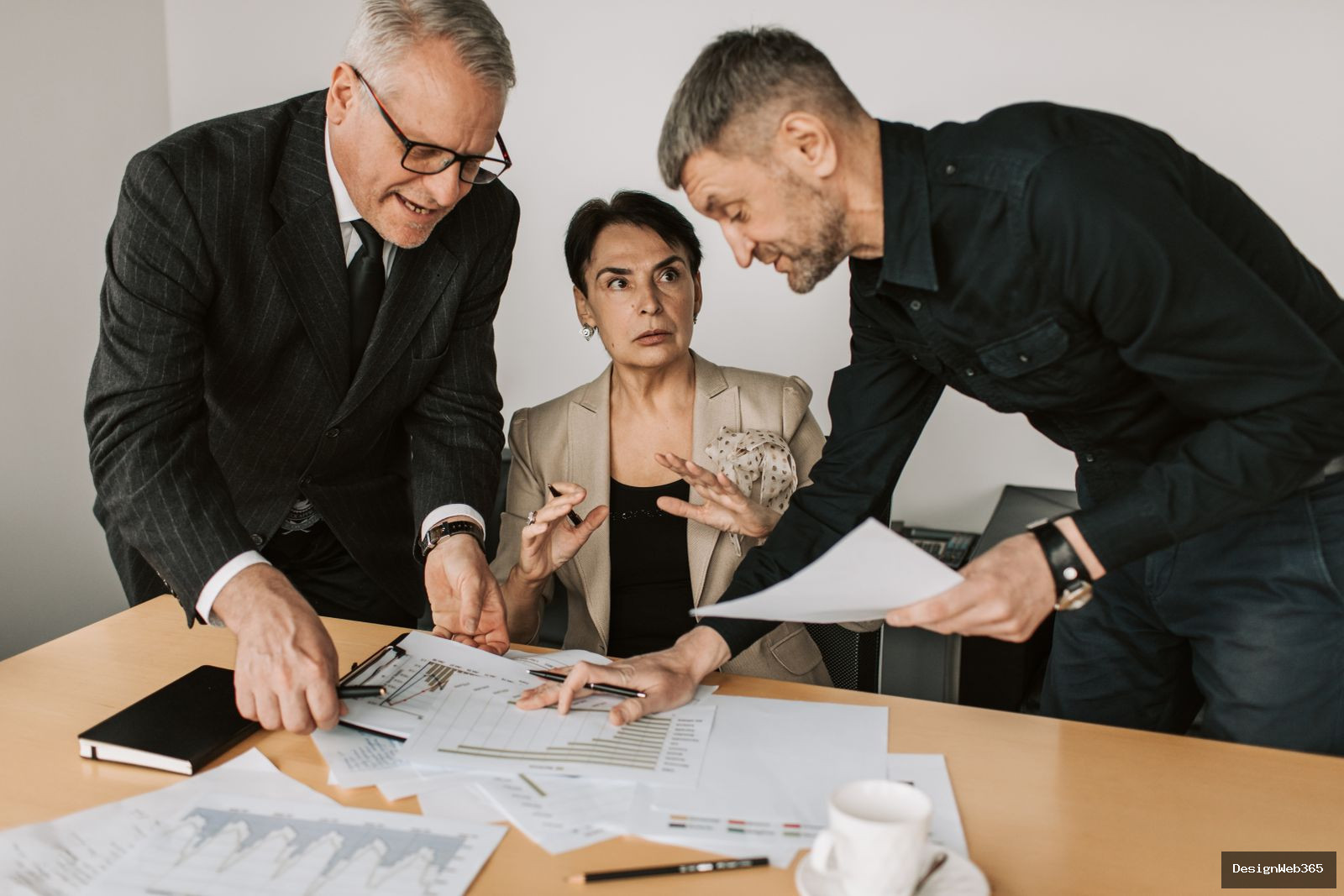 Discussion de travail autour d'une table de bureau avec documents et planning